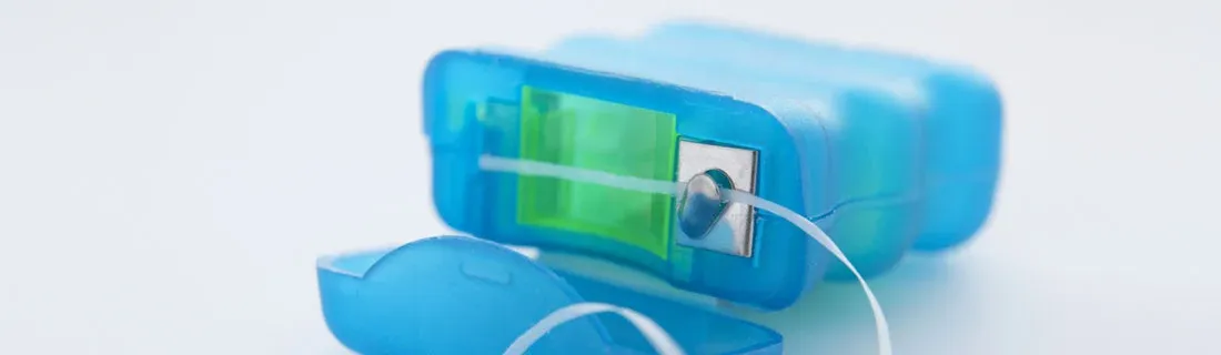 Close-up of a blue dental floss dispenser